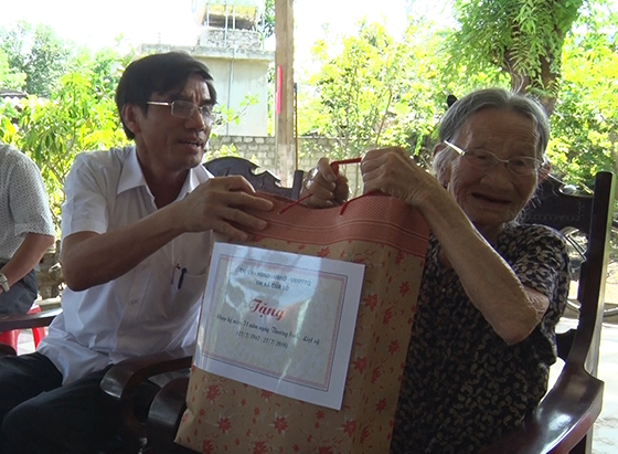Đồng chí Doãn Tiến Dũng - Phó bí thư Thi ủy - Chủ tịch UBND thị xã trao tặng quà cho Mẹ VNAH Trương Thị Kính - phường Nghi Hải.