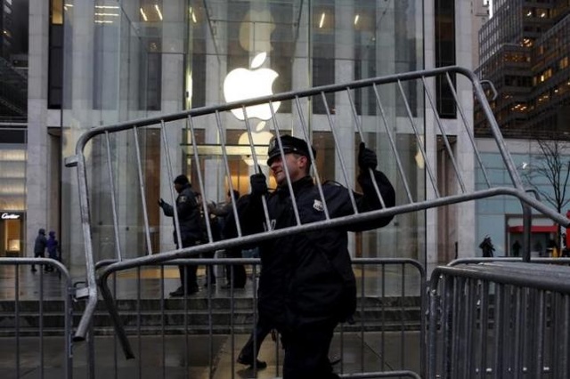 1 sỹ quan cảnh sát New York đang dựng hàng rào bên ngoài 1 cửa hàng của Apple tại New York hôm 23/3