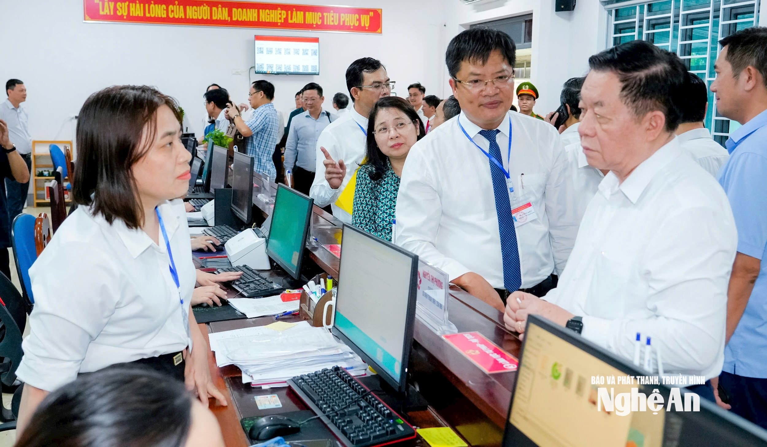 Trưởng ban Tuyên giáo và Dân vận Trung ương Nguyễn Trọng Nghĩa trao đổi với cán bộ làm việc tại Trung tâm hành chính công phường Cửa Lò. Ảnh: Phạm Bằng